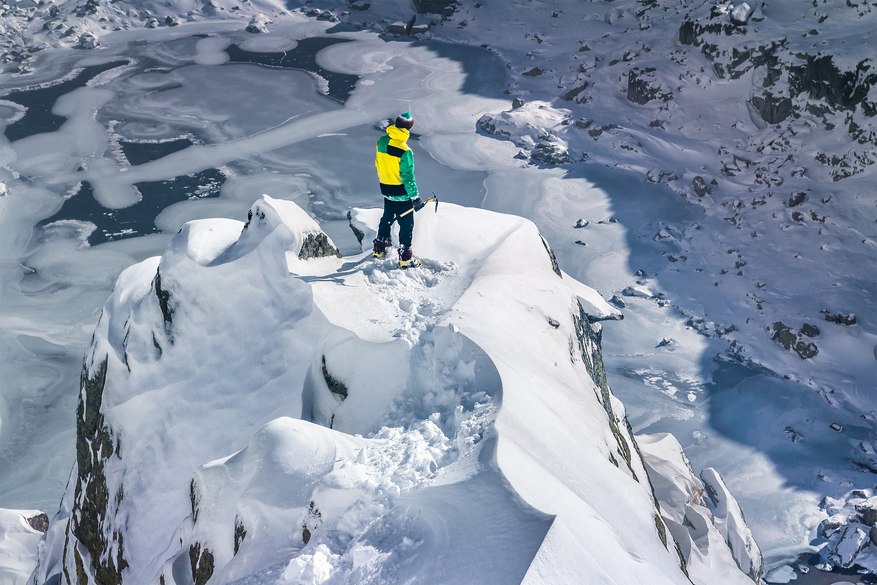 Un professionnel de la montagne debout sur un sommet enneigé